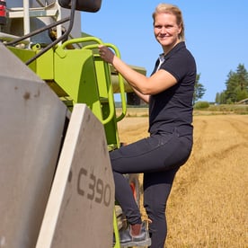 Elina is climbing onto the combine harvester.